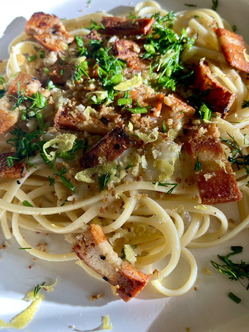 Vegan garlic linguine with crispy vegan bacon and fresh herbs.