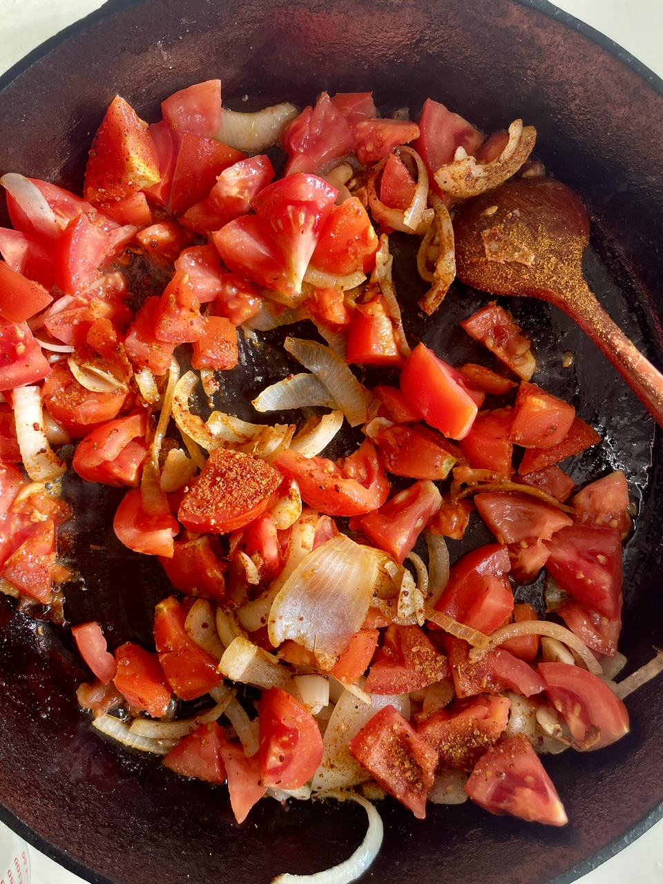 Sautéed tomatoes, onions, and spices in a skillet for Turkish stuffed eggplant.