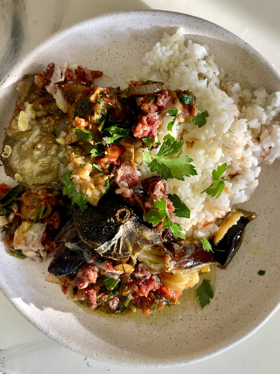 Turkish stuffed eggplant with tomatoes, onions, and herbs served with rice.